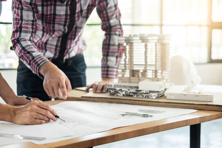 Close-up Of Person's engineer Hand Drawing Plan On Blue Print with architect equipment, Architects discussing at the table, team work and work flow construction concept.の写真素材