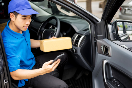 messenger man hold box and talk on smart phone and payment terminal in hands, Package delivery conceptの写真素材