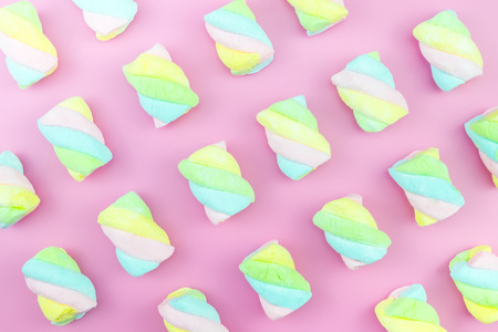 Flat lay top view tasty appetizing concept, minimal Sweet Treat Swirl Candy Lollipop marshmallow Colorful pattern on pink pastel background and copy spaceの写真素材
