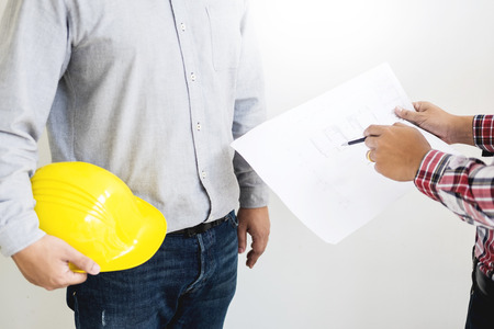 Close-up Of Person's engineer Hand Drawing Plan On Blue Print with architect equipment, Architects discussing at the table, team work and work flow construction concept.の写真素材
