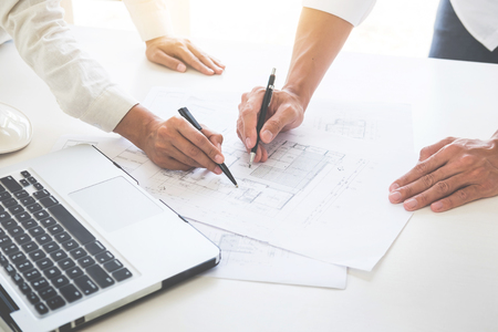 Close-up Of Person's engineer Hand Drawing Plan On Blue Print with architect equipment, Architects discussing at the table, team work and work flow construction concept.の写真素材