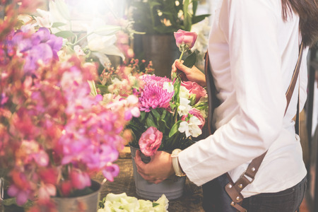 young women business owner florist making bouquet  in front of flower shopの写真素材