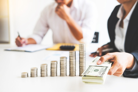 stacks of coins business accounting with saving money  concept calculator counting, making notes at home, hand is writes in a notebook. Stacked coins arranged, graph, chart and pen.の写真素材
