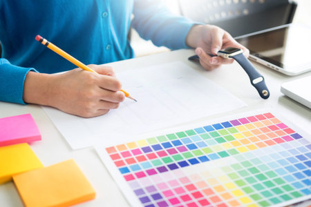 interior design or graphic designer renovation and technology concept - woman working with colour samples for selection. at workplace choosing colour swatches, closeup. Creative peopleの写真素材
