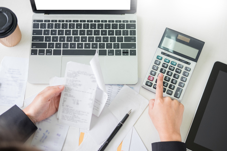 business woman accountant or banker making calculations Bills. doing finances in the office, economy concept through laptop.の写真素材