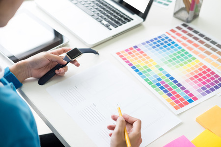 interior design or graphic designer renovation and technology concept - woman working with colour samples for selection. at workplace choosing colour swatches, closeup. Creative peopleの写真素材