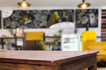 Selected focus empty brown wooden table and Coffee shop or restaurant blur background with bokeh...