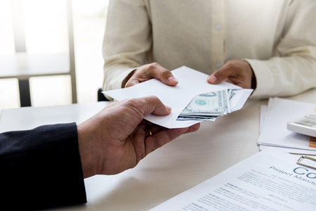 Corrupted businessman, or politician bribe in the form of hundred dollar bills. among high-ranking officials.の写真素材
