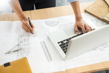 Person's engineer Hand Drawing Plan On Blue Print with architect equipment, Architects working at...