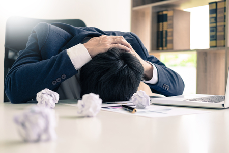 Depressed failure and tired businessman late sad and solving problem in office. in meeting room. stressed and worried at work crisis concept.の写真素材