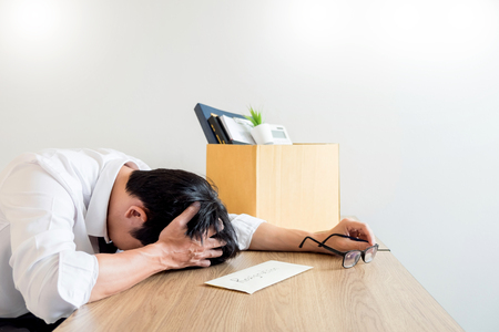 Businessmen are holding resignation document and packing personal company on brown cardboard box changing work, unemployment or resign concept.の写真素材