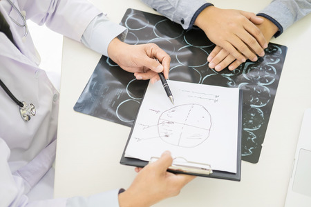 doctor giving a consultation discussing to patient and explaining medical informations and diagnosis, Medicine and health care concept.の写真素材