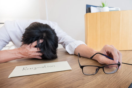 Businessmen are holding resignation document and packing personal company on brown cardboard box...