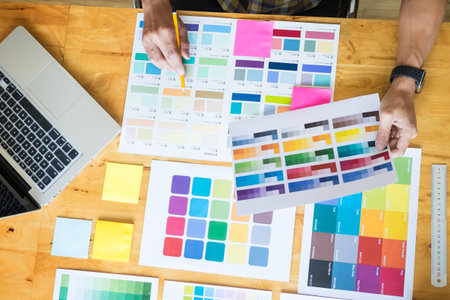 Creative Graphic designer at work. Color swatch samples pantone palette in studio modern office,...