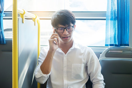 Passenger transport. people in the bus. man rides a bus, listening or calling to music and typing a message while riding homeの写真素材