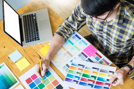 Professional Creative architect graphic desiner occupation choosing the Color pantone  palette samples for project on office desktop computerの写真素材