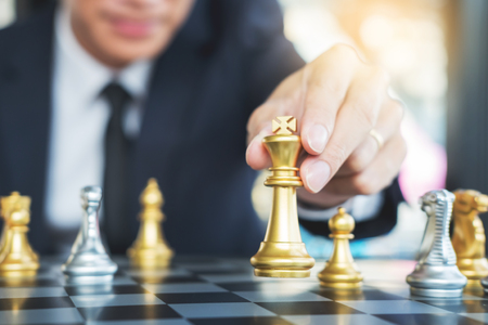 businessman playing  chess figure take a checkmate another king with team, strategy or management win or success conceptの写真素材
