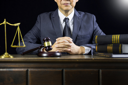 justice and law concept.Male judge in a courtroom working on wood table with documents., attorney court judge justice gavel legal legislation conceptの写真素材