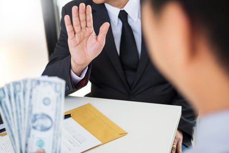 Businessman refuses to receive money that come with agreement paper - no bribery and corruption conceptの写真素材