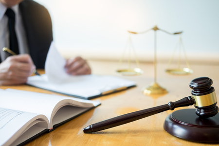 Male lawyer working with contract papers and reading law book in a courtroom, justice and law concept while presiding over trialの写真素材
