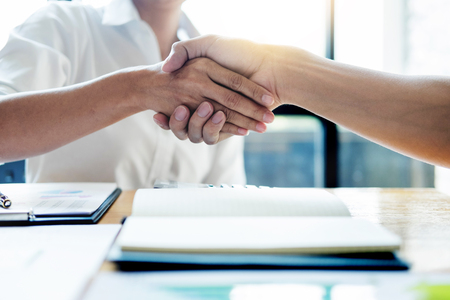 Negotiating business, Two confident business man shaking hands with partners together after finishing up a meeting succeeded Connection Deal Conceptの写真素材