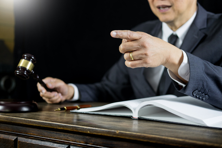 Lawyer or judge consult meeting with client at a law firm about legal legislation in courtroom with Judge gavel and Gold brass balance scaleの写真素材