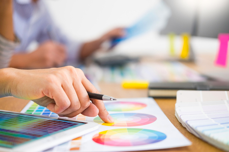 designer graphic creative creativity working together coloring using graphics tablet and a stylus at desk with colleagueの写真素材