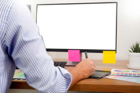 designer Editor at work drawing sketches a new project on graphic tablet and color palette sitting at desk with computer at studio or office.の写真素材