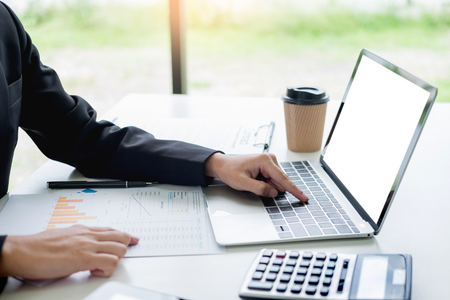 business woman with laptop, Business team working on a new business plan with modern digital computer, finance graph and writes on a document at her office.の写真素材