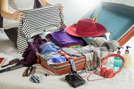 Woman hand packing a luggage for a new journey and travel for a long weekendの写真素材