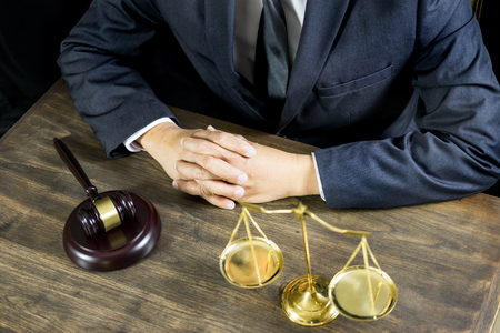 justice and law concept.Male judge in a courtroom working on wood table with documents., attorney court judge justice gavel legal legislation conceptの写真素材