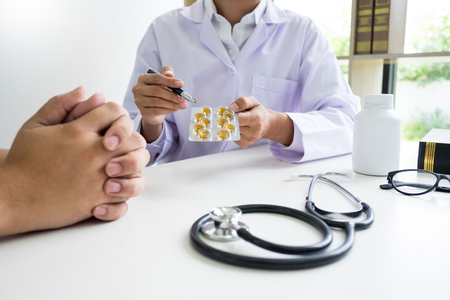 doctor hand holding tablet of drug and explain to patient in hospital roomの写真素材