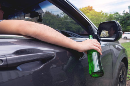 Don't Drink for Drive concept, Young Drunk man drinking bottle of beer or alcohol during driving the...