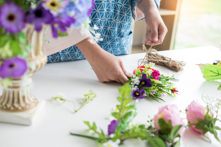 young women business owner florist making or Arranging Artificial flowers vest in her shop, craft and hand made concept.の写真素材