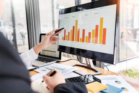 two young businessmen partner explaining information and pointing at report data discussing strategy...