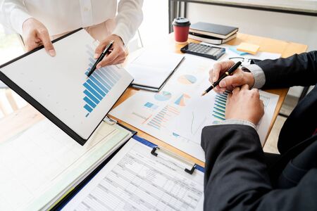 businessmen discussing project at meeting pointing explaining his idea charts and graph colleague at work having a meeting for project discussion.の写真素材