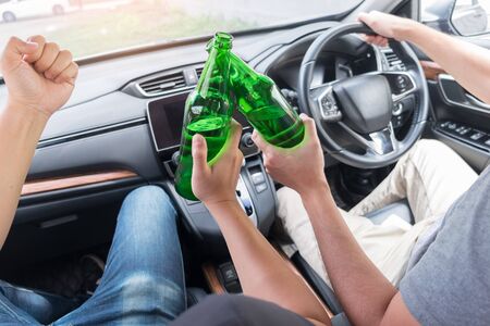 Don't Drink for Drive concept, Young Drunk man drinking bottle of beer or alcohol during driving the car dangerously.の写真素材