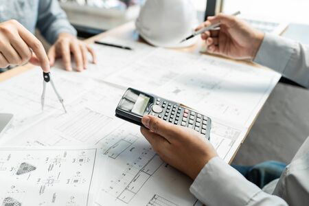 Realestate concept, Two engineer and architect discussing blueprints data working and digital tablet on construction building projectの写真素材