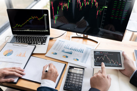 Team of stockbrokers Discussing with display screens Analysing data, graphs and reports of stock...
