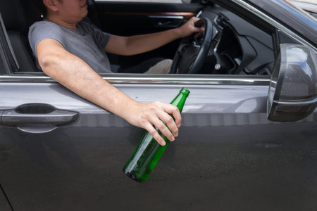 Don't Drink for Drive concept, Young Drunk man drinking bottle of beer or alcohol during driving the car dangerously.の写真素材
