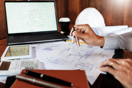 Realestate concept, Two engineer and architect discussing blueprints data working and digital tablet...