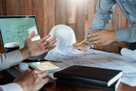 Confident engineer team working with Blue Print with architect equipment discussing and Planning work flow construction project. with partner at the table in office work site.の写真素材
