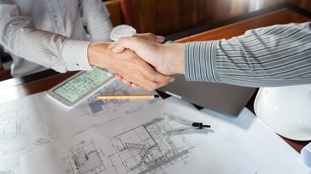 Architect and engineer construction workers shaking hands while working for teamwork and cooperation concept after finish an agreement in the office construction site, success collaboration conceptの写真素材