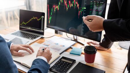 Team of stockbrokers Discussing with display screens Analyzing data, graphs and reports of stock market trading for investmentの写真素材