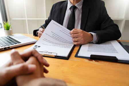 A Young Female Business women Applicant In Office Male Manager Interviewing holding resume and speaking to employer, job Interview employment and recruitment conceptの写真素材