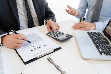 Confident insurance agent broker man holding document and present pointing showing an insurance policy contract form to client  Business Communication Connection Conceptの写真素材