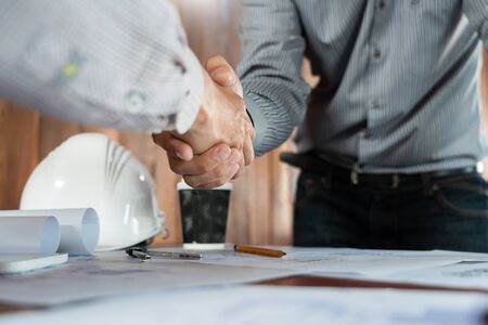 Architect and engineer construction workers shaking hands while working for teamwork and cooperation concept after finish an agreement in the office construction site, success collaboration conceptの写真素材