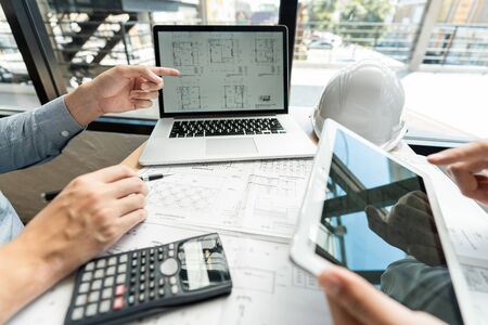 Real-estate concept, Two engineer and architect discussing blueprints data working and digital tablet on construction building projectの写真素材