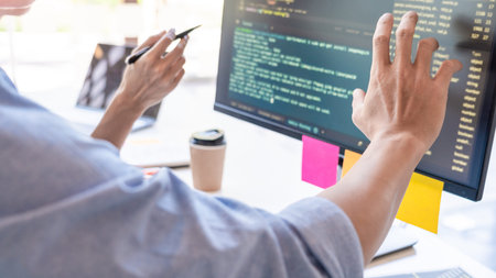 Young startup Programmers Sitting At Desks Working On Computers screen for Developing programming...