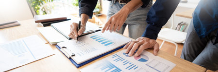 Business People Meeting to analyse and discuss and brainstorming the financial report chart data in...
